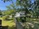Two-story home surrounded by mature trees and manicured lawn with a fence and large green bushes at 11609 Us 401, Fuquay Varina, NC 27526