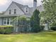 Traditional grey two-story home showing the left side with a chimney, well-manicured landscaping, and a lush green lawn at 11609 Us 401, Fuquay Varina, NC 27526