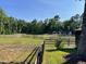 This photo shows a large, fenced pasture with a three-stall building in the background at 11609 Us 401, Fuquay Varina, NC 27526