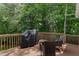 Outdoor deck with grill, wooded backyard view, and comfortable seating for entertaining or relaxation at 118 Killingsworth Dr, Cary, NC 27518
