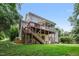 A beautiful backyard features a wooden deck and screened in porch with stairs descending to a beautiful lawn at 118 Killingsworth Dr, Cary, NC 27518