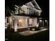 Inviting two-story home featuring stone accents, a covered porch with seating, and an attached two-car garage at night at 118 Killingsworth Dr, Cary, NC 27518