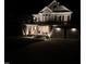 Inviting two-story home featuring stone accents, a covered porch with seating, and an attached two-car garage at night at 118 Killingsworth Dr, Cary, NC 27518