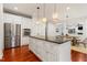 Open kitchen features stainless appliances, hardwood floors, white cabinets and granite countertops at 118 Killingsworth Dr, Cary, NC 27518