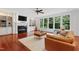 Bright living room features fireplace, built-in shelving, hardwood floors and three large windows at 118 Killingsworth Dr, Cary, NC 27518