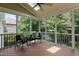 Inviting screened porch with comfortable seating, ceiling fan, skylight, and a serene wooded view at 118 Killingsworth Dr, Cary, NC 27518