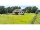 Expansive backyard featuring lush green lawn, mature trees, and a charming back porch at 120 Firefly Ln, Louisburg, NC 27549