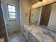 Bathroom featuring dual sinks, white cabinetry, and granite counters next to the shower at 120 Firefly Ln, Louisburg, NC 27549