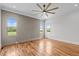 Bedroom features hardwood floors, decorative accent wall, and windows with views of the landscape at 120 Firefly Ln, Louisburg, NC 27549