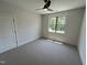 Cozy bedroom features neutral carpet, ceiling fan, window overlooking trees, and ample natural light at 120 Firefly Ln, Louisburg, NC 27549