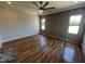 Bright bedroom featuring hardwood floors, a modern ceiling fan, and stylish accent wall at 120 Firefly Ln, Louisburg, NC 27549