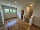 Upstairs bonus room features hardwood flooring and a bright window, leading to stairway and an extra storage closet at 120 Firefly Ln, Louisburg, NC 27549