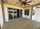 A covered outdoor patio features a wood deck, ceiling fan, and sliding glass doors at 120 Firefly Ln, Louisburg, NC 27549