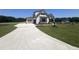 New construction home featuring a long concrete driveway, two-car garage, and landscaped front yard at 120 Firefly Ln, Louisburg, NC 27549