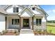 Inviting front entrance features double doors and stone accents, enhanced by a covered porch at 120 Firefly Ln, Louisburg, NC 27549