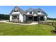 Charming white and stone home with green lawn and professionally landscaped flower beds at 120 Firefly Ln, Louisburg, NC 27549
