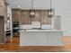 Spacious kitchen with custom cabinets, stainless steel appliances, a large island, and modern pendant lighting at 120 Firefly Ln, Louisburg, NC 27549