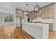 Spacious kitchen with custom cabinets, stainless steel appliances, a large island, and modern pendant lighting at 120 Firefly Ln, Louisburg, NC 27549
