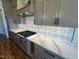 Stylish kitchen features stainless steel gas range, stone countertops, and decorative backsplash at 120 Firefly Ln, Louisburg, NC 27549