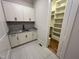 Convenient laundry room with white cabinetry, utility sink, granite countertop and a door to the pantry at 120 Firefly Ln, Louisburg, NC 27549