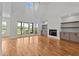Spacious living room with hardwood floors, fireplace, built-ins, and sliding doors to the outdoor deck at 120 Firefly Ln, Louisburg, NC 27549