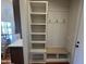 Charming mudroom with built-in bench, hooks, open shelving, and stylish design details at 120 Firefly Ln, Louisburg, NC 27549