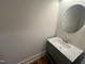 Updated powder room boasts a modern vanity, marble countertop, and a round mirror at 120 Firefly Ln, Louisburg, NC 27549
