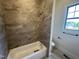 Shower with tan tile and a shower/tub combo next to a window and the toilet at 120 Firefly Ln, Louisburg, NC 27549