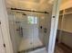 Modern walk-in shower with glass enclosure and elegant tile work, adjoined to walk in closet at 120 Firefly Ln, Louisburg, NC 27549