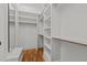 A closet with open shelving and wooden rods and a wood floor at 120 Firefly Ln, Louisburg, NC 27549