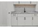 Wet bar with tile backsplash, granite countertop, sink, and white cabinets at 120 Firefly Ln, Louisburg, NC 27549