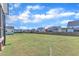 Large grassy backyard with a black iron fence and neighborhood views; ideal for outdoor activities and relaxation at 121 Nate Ct, Wake Forest, NC 27587
