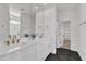 Elegant bathroom featuring dual vanity sinks with bronze fixtures, black floors, and paneled accent wall at 121 Nate Ct, Wake Forest, NC 27587