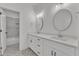 Modern bathroom featuring dual vanities with round mirrors and stylish patterned tile flooring at 121 Nate Ct, Wake Forest, NC 27587