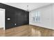 Dining room featuring a modern chandelier, white trim, hardwood floors, and black accent wall at 121 Nate Ct, Wake Forest, NC 27587