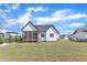 Rear exterior of a white home with a screened-in porch and a well-kept lawn; an inviting outdoor living space at 121 Nate Ct, Wake Forest, NC 27587
