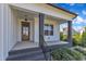 Inviting front porch with dark pillars and stained wood front door at 121 Nate Ct, Wake Forest, NC 27587