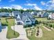 Aerial view of a two-story home with a well-manicured lawn, complemented by a paved driveway and landscaping at 121 Nate Ct, Wake Forest, NC 27587