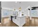 Open kitchen with white island, stainless steel sink, and views of a fireplace and sunroom at 121 Nate Ct, Wake Forest, NC 27587