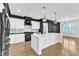 Modern kitchen with white cabinets, black countertops, and stainless steel appliances at 121 Nate Ct, Wake Forest, NC 27587