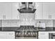 Close up of kitchen featuring stainless steel oven with black range hood and marble backsplash at 121 Nate Ct, Wake Forest, NC 27587