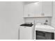 Bright laundry room featuring a modern washer and dryer, and white cabinets for ample storage at 121 Nate Ct, Wake Forest, NC 27587