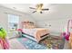 Bright bedroom features a bed, area rug, large window with natural light and ceiling fan at 137 Clydes Point Way, Wendell, NC 27591
