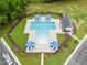 Overhead view of a community pool featuring ample seating, blue umbrellas, and meticulously landscaped surroundings at 137 Clydes Point Way, Wendell, NC 27591