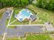 Aerial view of a community pool with lounge chairs, umbrellas, and a spacious parking area, perfect for summer enjoyment at 137 Clydes Point Way, Wendell, NC 27591