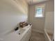 Bright bathroom featuring a white vanity with stone countertop and a window providing natural light at 145 Tee Dr, Selma, NC 27576