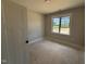 Neutral bedroom features a large window with a view and white trim and baseboards at 145 Tee Dr, Selma, NC 27576