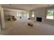 Spacious living room with a fireplace, large windows, and access to the kitchen and backyard at 145 Tee Dr, Selma, NC 27576