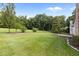 Expansive backyard featuring a lush green lawn and mature trees providing ample shade and privacy at 1614 E Hardscrabble Dr, Hillsborough, NC 27278