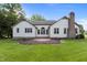 Expansive backyard with lush green lawn, mature trees, and a charming brick patio, great for entertaining at 1614 E Hardscrabble Dr, Hillsborough, NC 27278